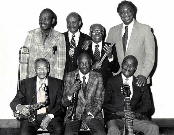 The Harlem Blues and Jazz Band, au Ginger Man Restaurant, NYC, 1981: assis de g. à d., George James (as),  Bobby Williams (tp), Al Casey (g); debout de g. à d., Eddie Durham (tb), Johnny Williams (bar),  Tommy Benford (dm), Gene Rogers (p) © photo Albert Vollmer by courtesy